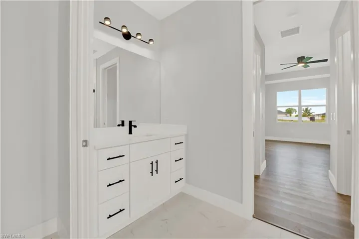 Bathroom featuring wood-type flooring, vanity, and ceiling fan
