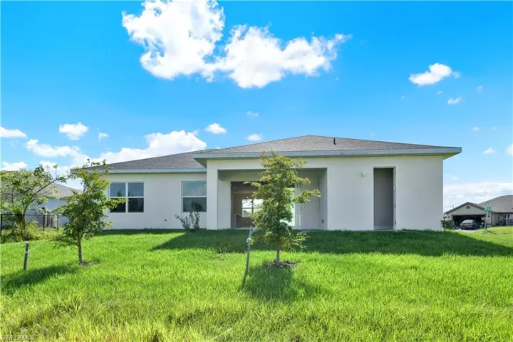 Rear view of property with a lawn