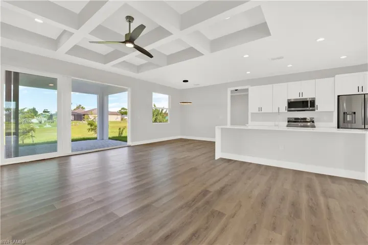 Unfurnished living room with coffered ceiling and wood-type flooring