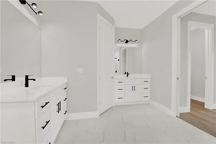 Bathroom featuring tile floors and dual bowl vanity