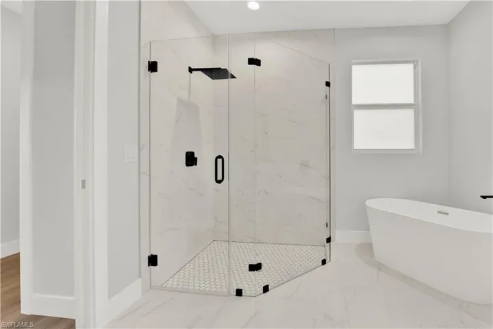 Bathroom with tile flooring and a shower with shower door