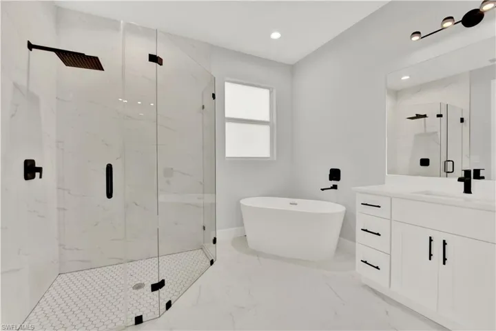 Bathroom with tile flooring, vanity, and independent shower and bath