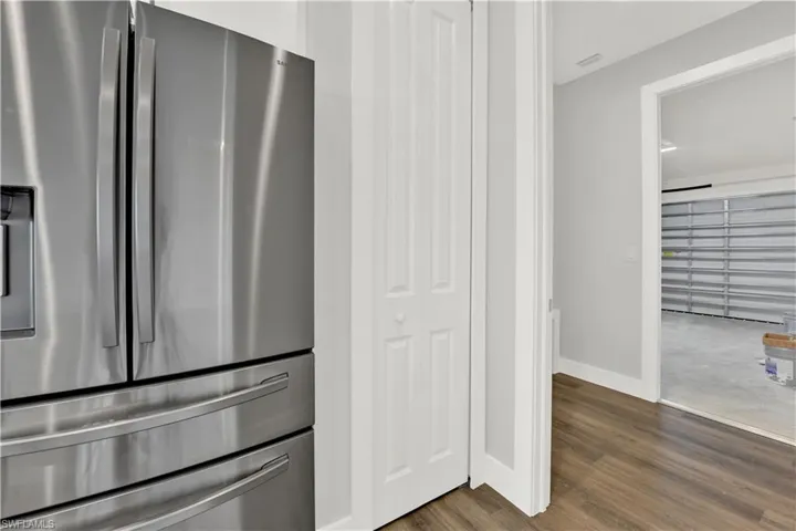 Kitchen featuring dark carpet and stainless steel refrigerator with ice dispenser