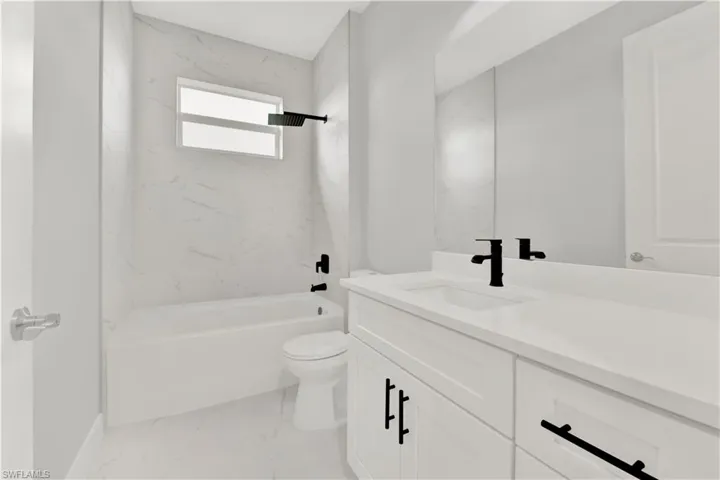 Full bathroom with tile floors, tiled shower / bath, toilet, and vanity