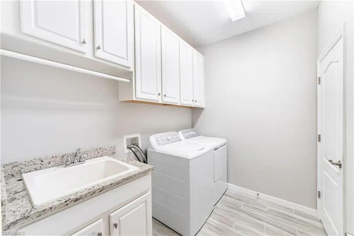 Drip bar over utility sink, and plenty of storage in cabinetry over washer/dryer.