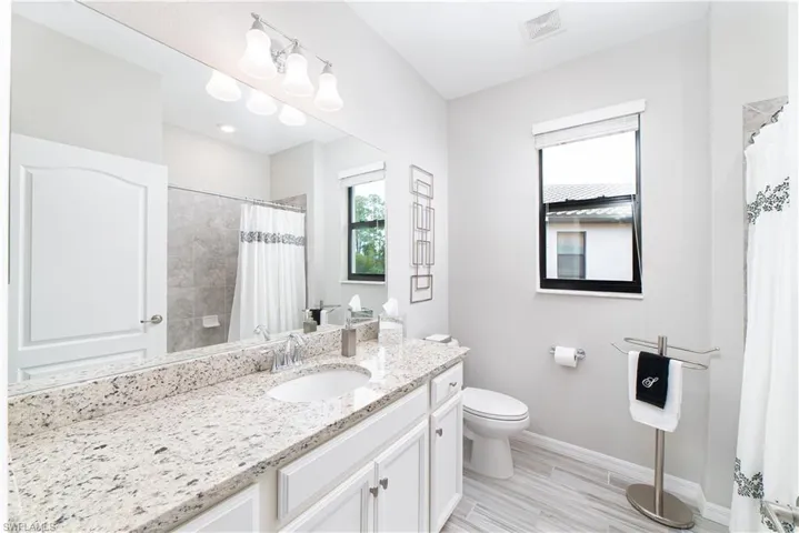 Guest bath with granite counters and tub/shower combination.