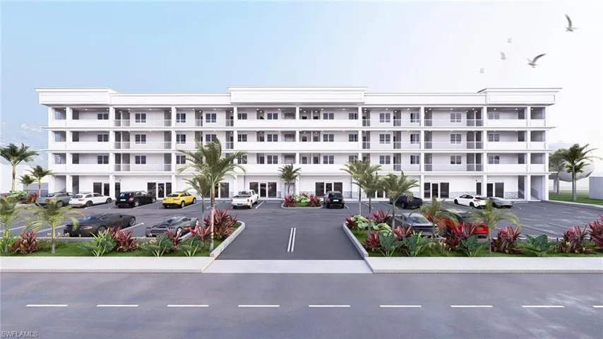 View of apartment building / complex featuring uncovered parking