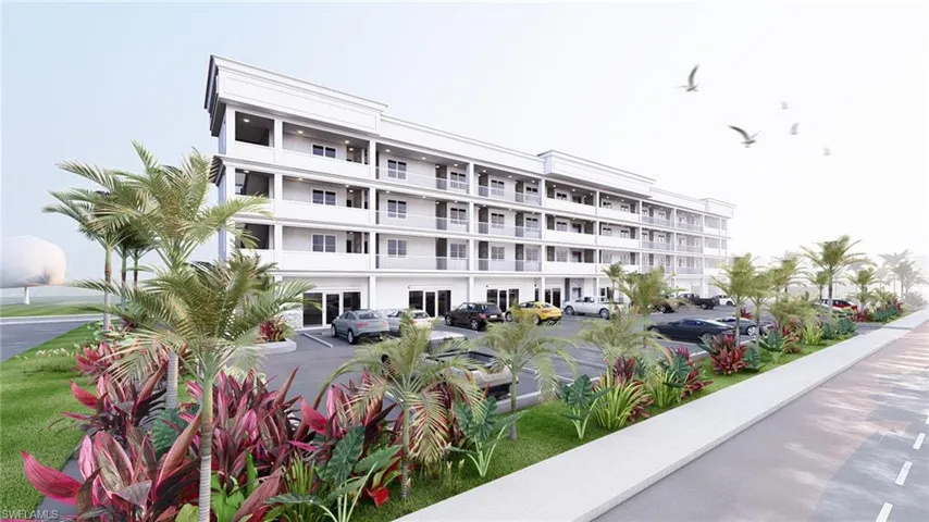 View of apartment building / complex with uncovered parking