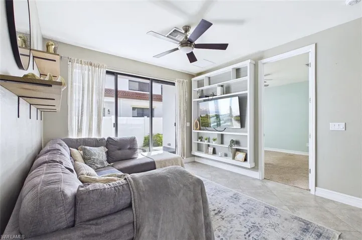 Living room featuring a ceiling fan and light tile patterned floors