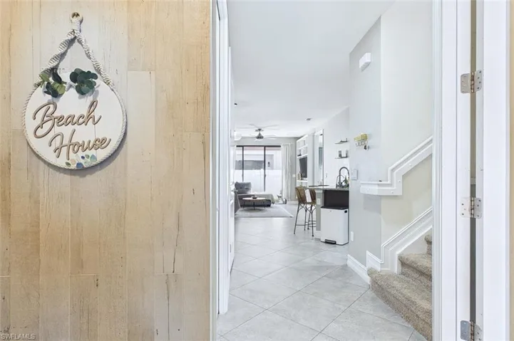 Hallway featuring stairway and light tile patterned flooring