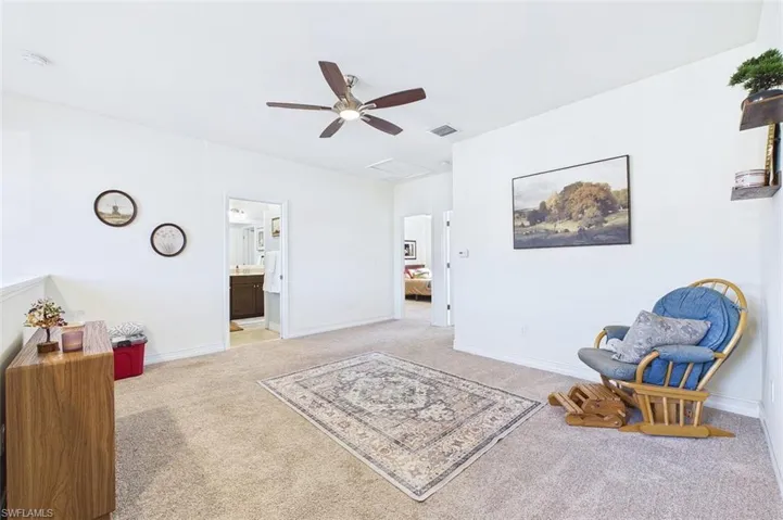 Sitting room featuring light colored carpet and a ceiling fan
