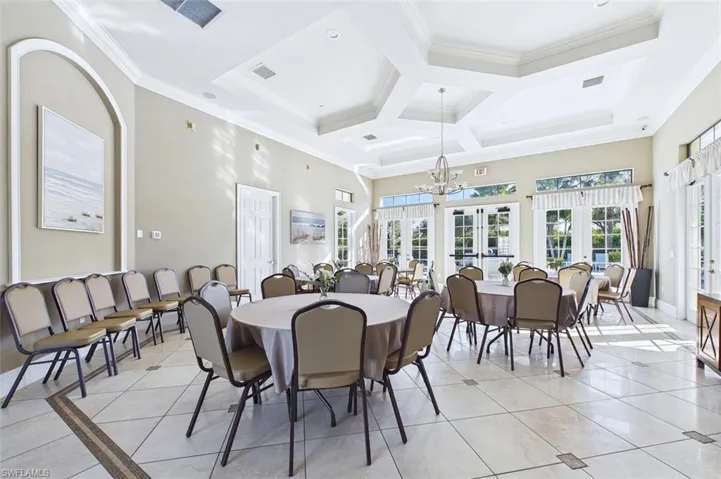 Dining room featuring light tile patterned floors, ornamental molding, french doors, coffered ceiling, and a towering ceiling