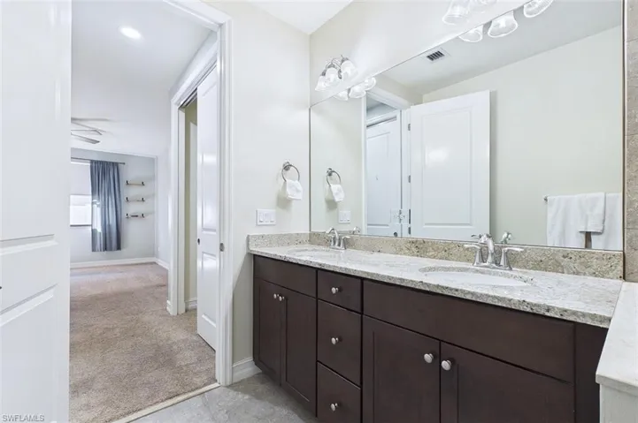 Bathroom featuring double vanity and light carpet