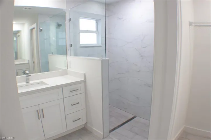 Contemporary bathroom featuring a frameless glass shower enclosure and a window