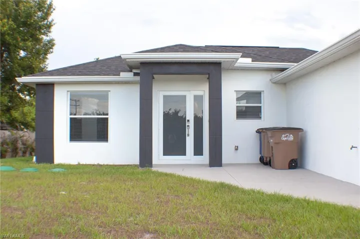 Contemporary exterior featuring a white stucco finish with dark contrasting architectural accents