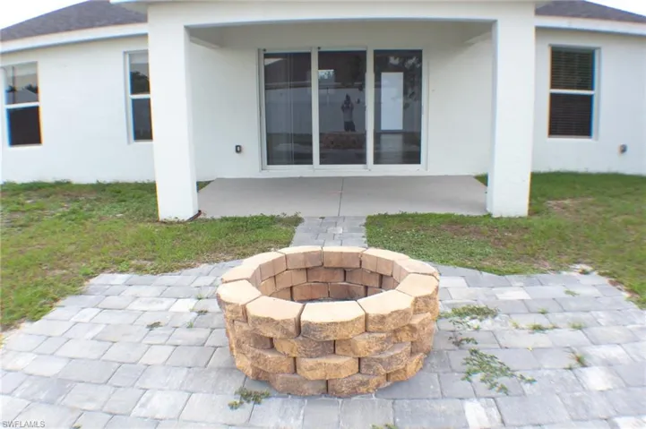Outdoor fire pit with stacked stone construction on a paver patio