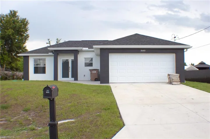 Contemporary ranch-style residence featuring a white and dark gray stucco exterior