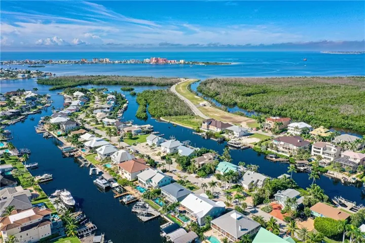 Aerial view of property and surrounding area featuring a nearby body of water and nearby suburban area