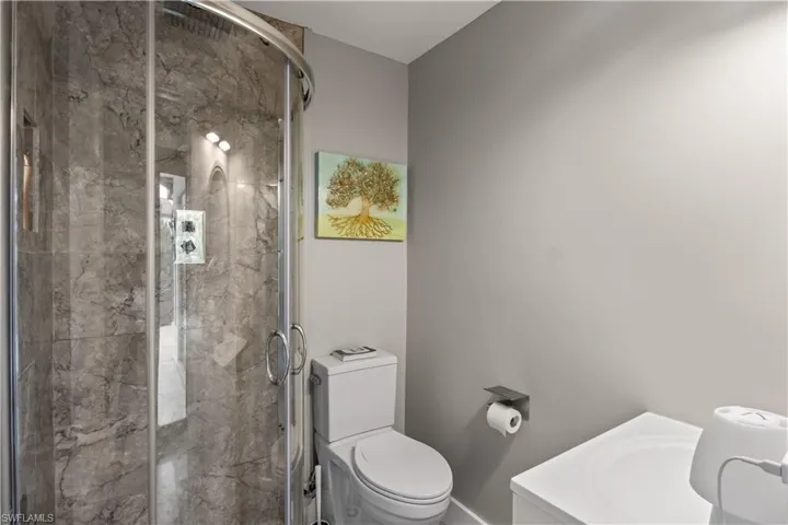 A bright, convenient bathroom just off the living area offers easy access to the pool, perfect for quick rinses and swimsuit changes.