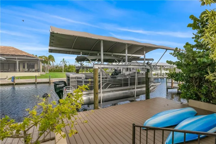 The boat dock extends over calm water, gently rocking with the breeze as boats sway at their moorings.