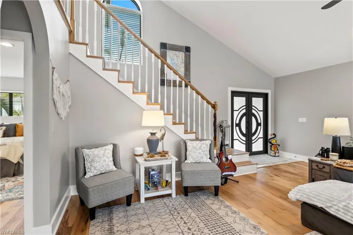 A welcoming entryway bathed in natural light features a graceful oak staircase that leads to the inviting upstairs guest rooms.