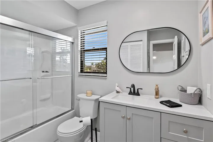 Second floor full bathroom with combined bath / shower with glass door, toilet, and vanity.