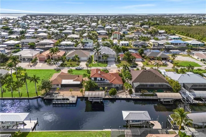 Breathtaking aerial shot of the dock and waterfront, offering a glimpse into relaxed coastal living with direct water access and endless recreation opportunities.