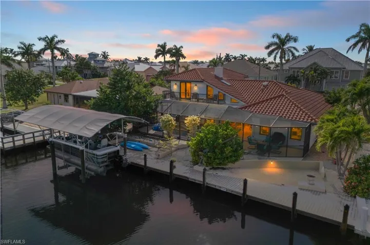 The boat dock extends over calm water, gently rocking with the breeze as boats sway at their moorings.