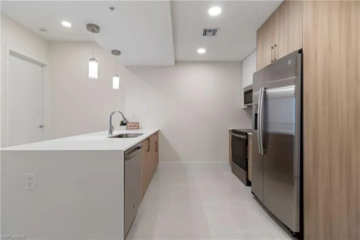 The modern kitchen is truly striking, featuring elegant quartz countertops, sleek stainless steel appliances, and a breathtaking waterfall island