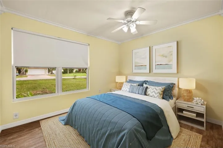 Bedroom featuring ceiling fan, ornamental molding, and hardwood / wood-style floors