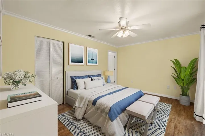 Bedroom with crown molding, dark wood-type flooring, ceiling fan, and a closet