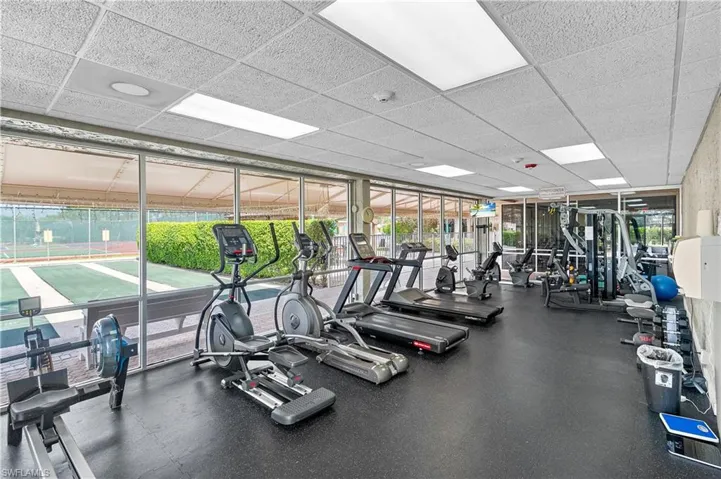 Workout area featuring plenty of natural light and a paneled ceiling