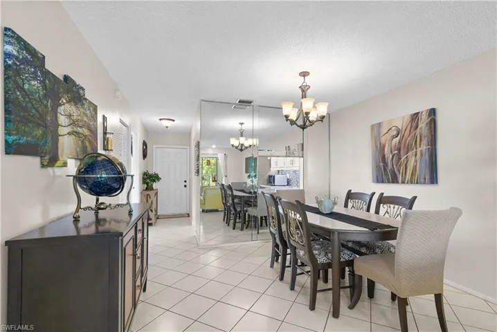 Dining room featuring a notable chandelier, a textured ceiling, and light tile floors