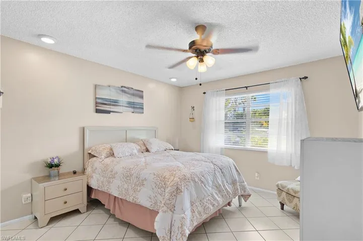 Master Bedroom with a ceiling fan, and light tile floors