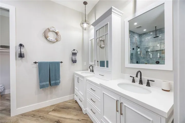 Dual vanity with white cabinetry and integrated sinks, complemented by dark bronze fixtures