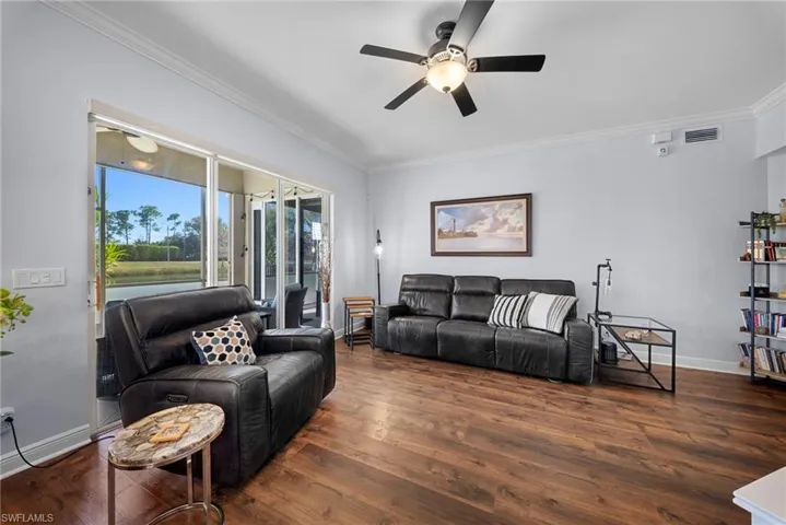 Living room featuring ornamental molding, ceiling fan