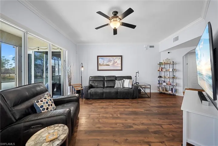 Living room with crown molding, and a ceiling fan