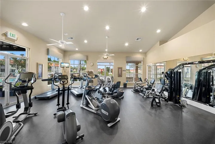Gym with ceiling fan, recessed lighting, and lofted ceiling