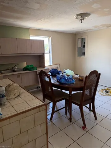 Dining room featuring electric panel, light tile patterned floors, and a textured ceiling
