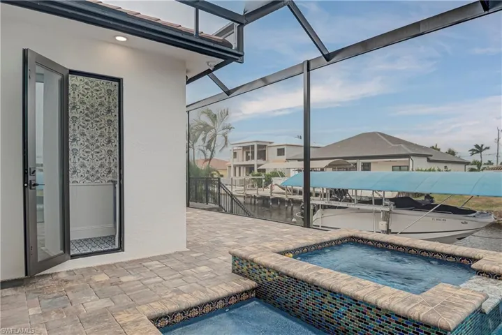 View of pool featuring a patio, an in-ground hot tub, a lanai, a sunroom, and a boat dock