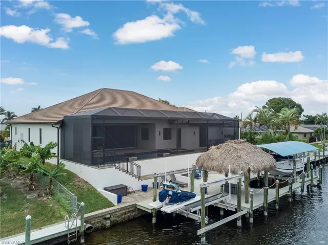 Dock with boat lift, a lanai, a sunroom, and a water view