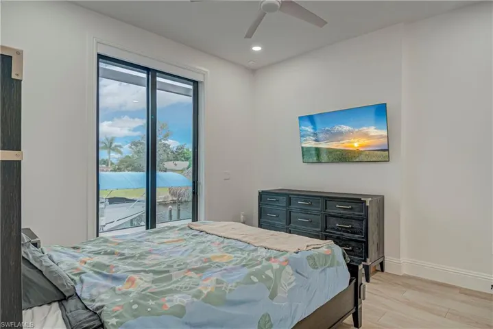 Bedroom featuring light wood finished floors, access to exterior, a ceiling fan, and recessed lighting