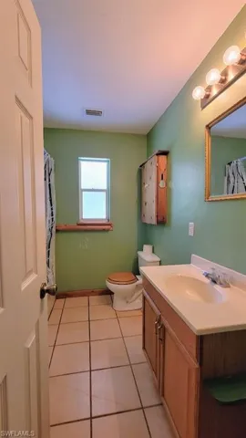 Bathroom featuring tile patterned floors, vanity, and toilet