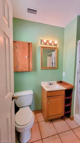 Bathroom featuring vanity, toilet, and tile patterned floors