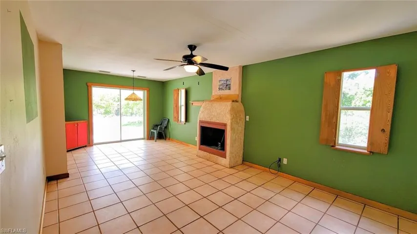 Unfurnished living room with ceiling fan and tile patterned floors