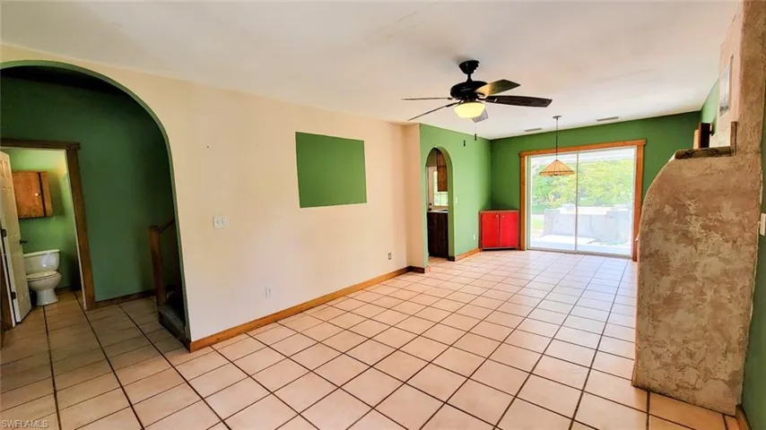 Unfurnished living room with tile patterned flooring and ceiling fan