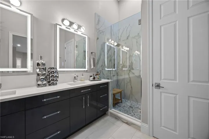 New cabinets, counters, mirrors and frameless glass door at the walk-in shower