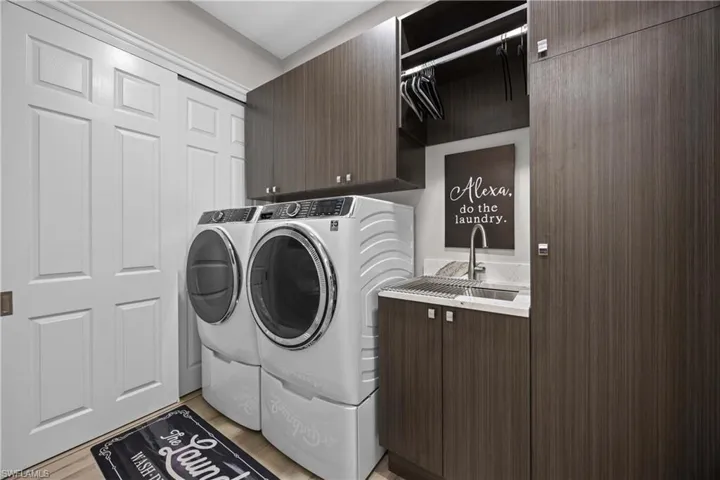 Laundry complete with a utility sink and plenty of cabinetry