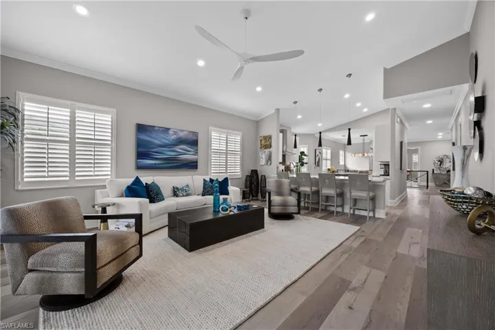 Open living room & kitchen - plantation shutters, high-end flooring, upgraded lighting & ceiling fan