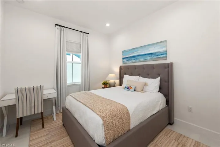 Bedroom featuring radiator heating unit, recessed lighting, and an office area